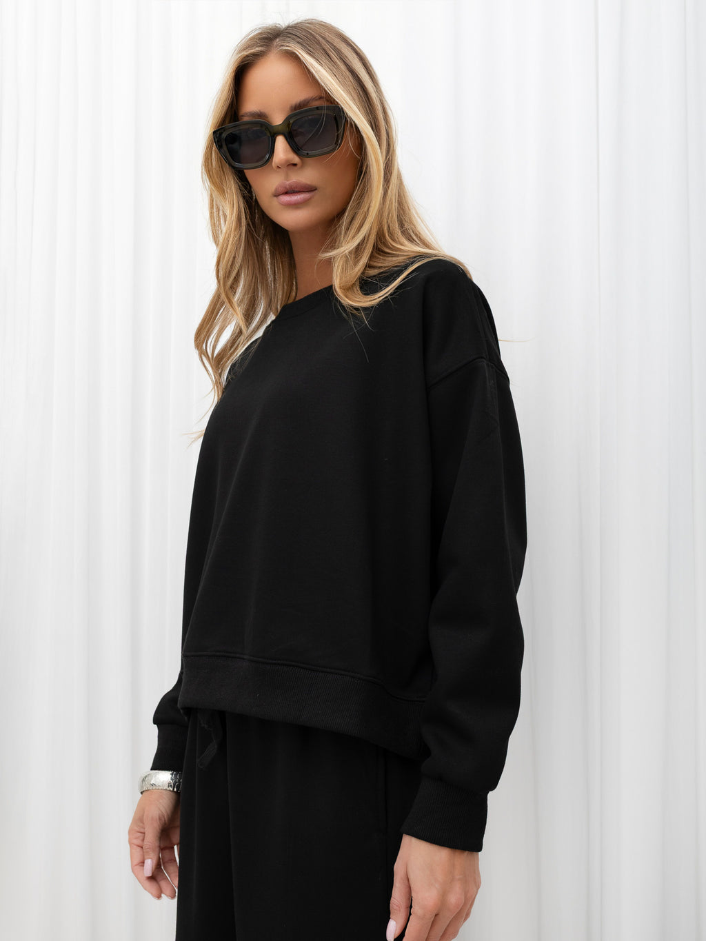 Czarny ocieplany komplet dresowy: bluza i szerokie spodnie – stylizacja na modelce, zdjęcie 3