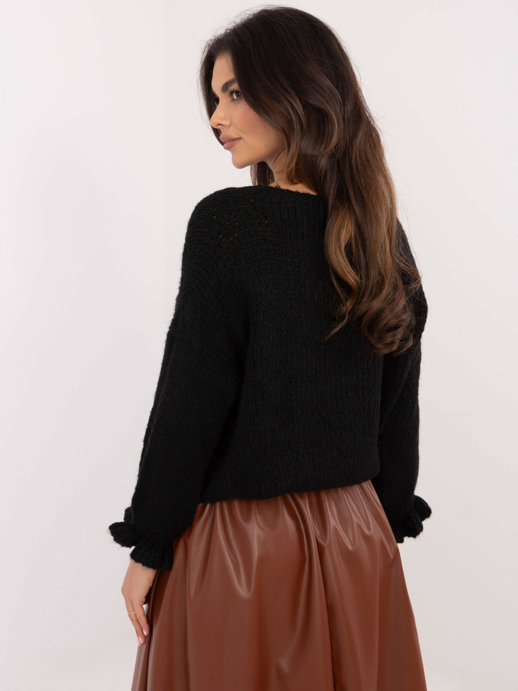 Czarny sweter oversize damski z falbankami przy rękawach – stylizacja na modelce, zdjęcie 4