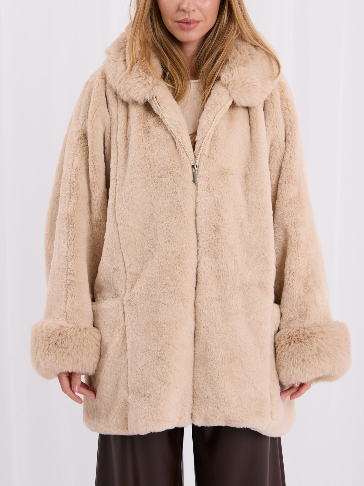 Jasnobeżowy płaszcz oversize ze sztucznego futra na zamek – stylizacja na modelce, zdjęcie 2