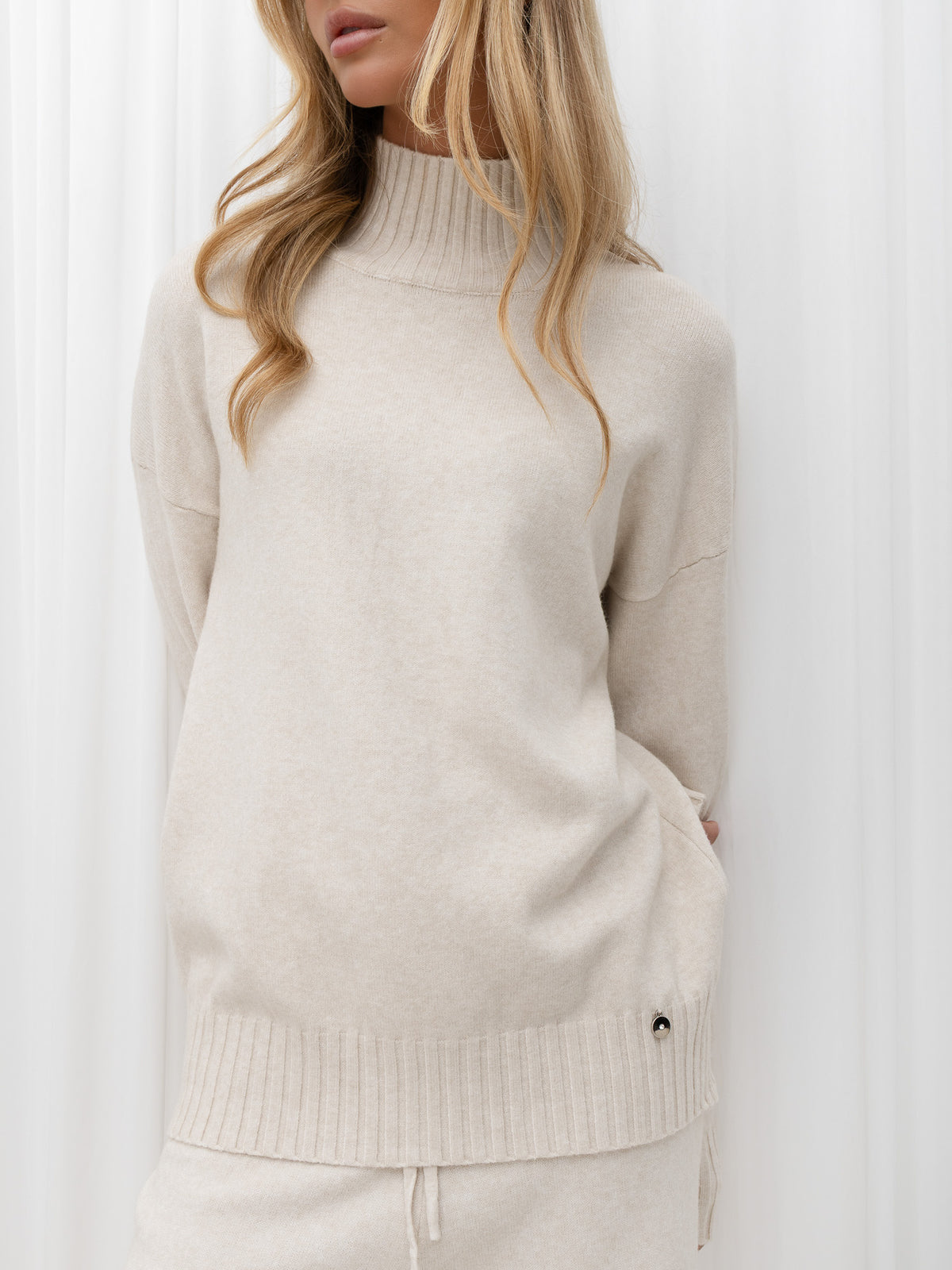 Jasnobeżowy komplet damski: sweter i spodnie wide leg – stylizacja na modelce, zdjęcie 3